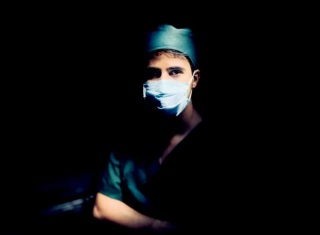 Operatore sanitario in divisa chirurgica con mascherina in sala operatoria